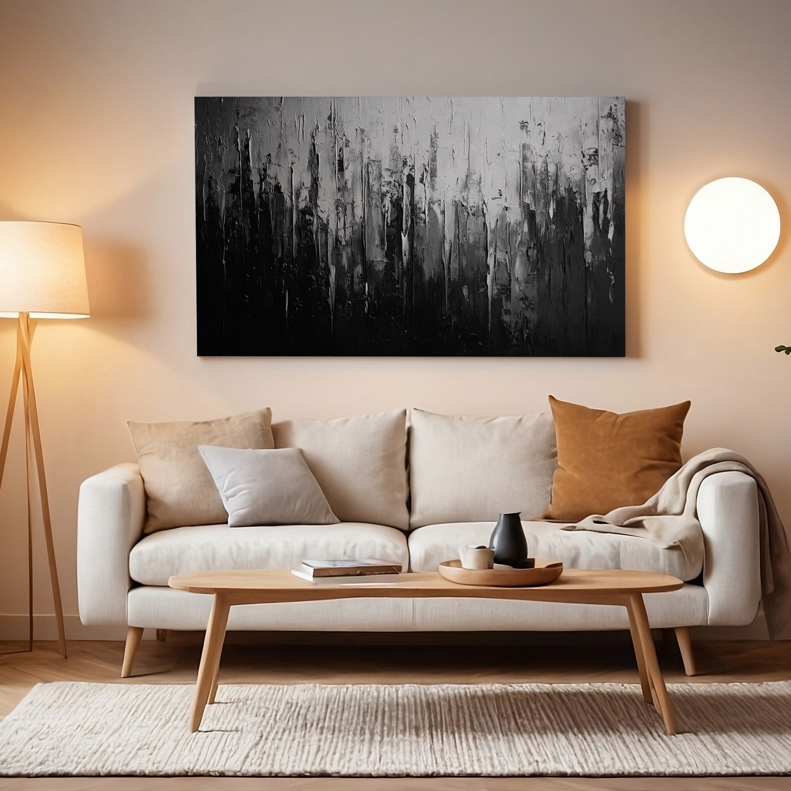 Abstract printable wall art in black and white tones with textured vertical brushstrokes, displayed above a modern beige sofa in a softly lit living room