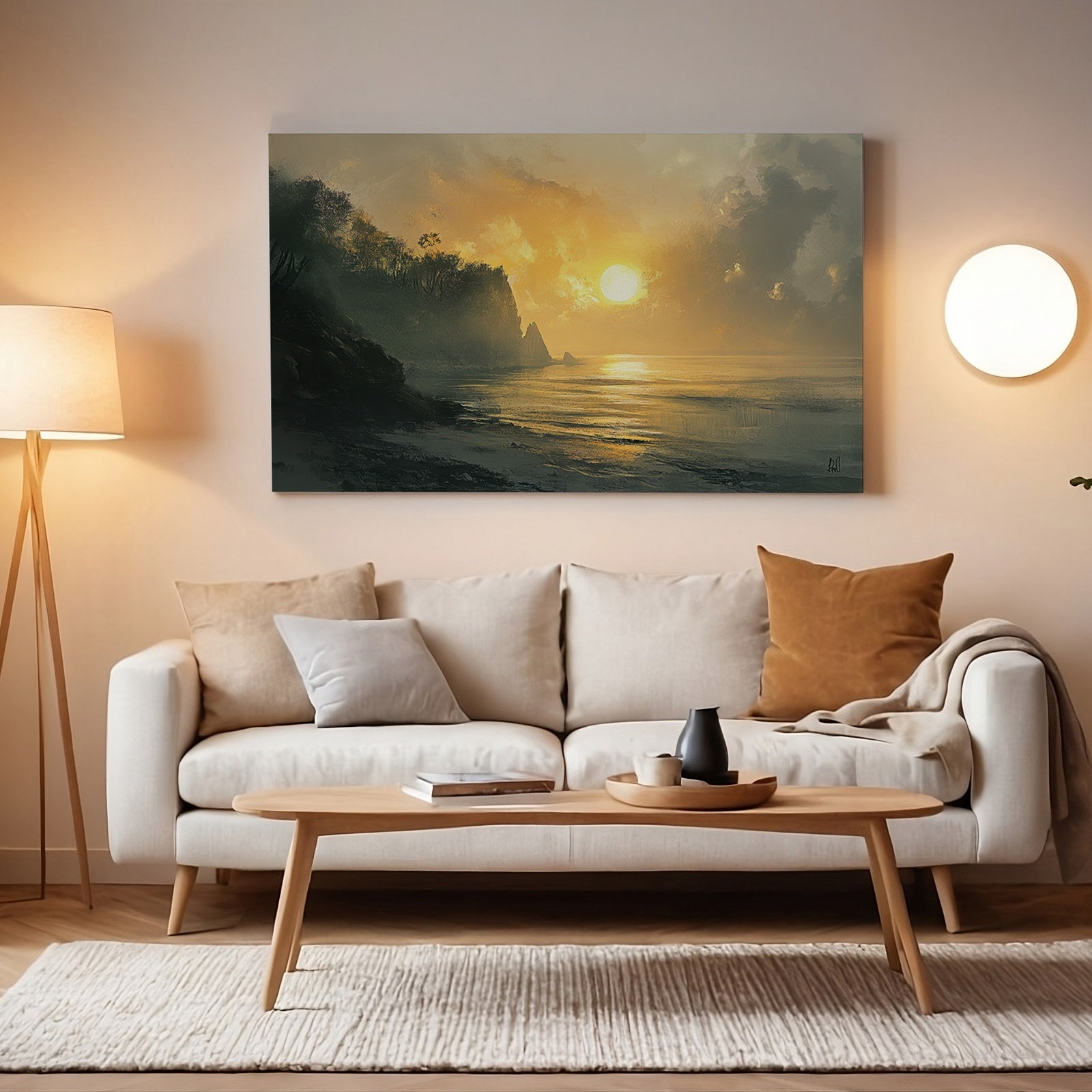 Coastal printable wall art depicting a golden sunset over the ocean with cliffs and calm waves, displayed above a modern beige sofa in a softly lit living room
